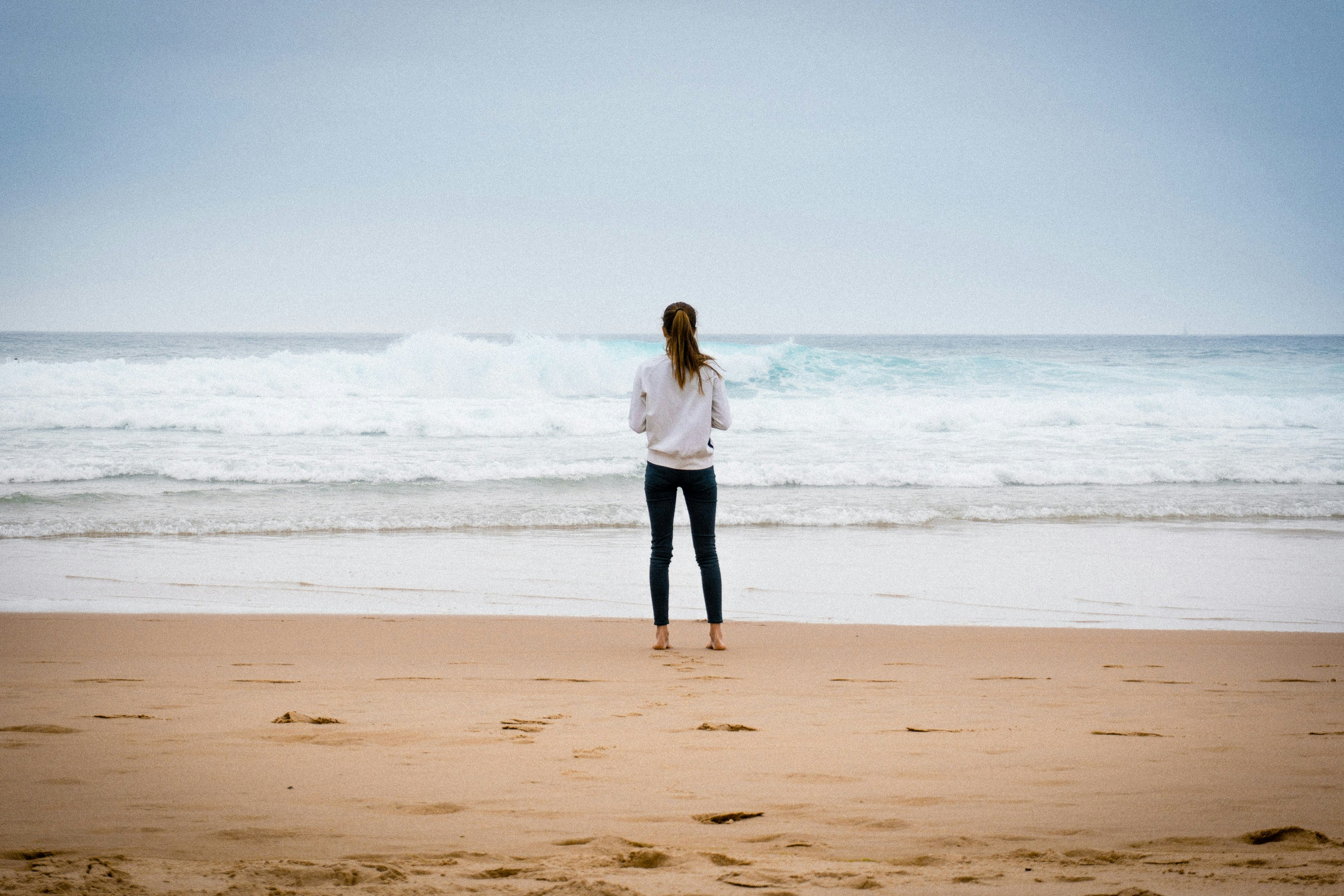 woman standing near seashore during daytime